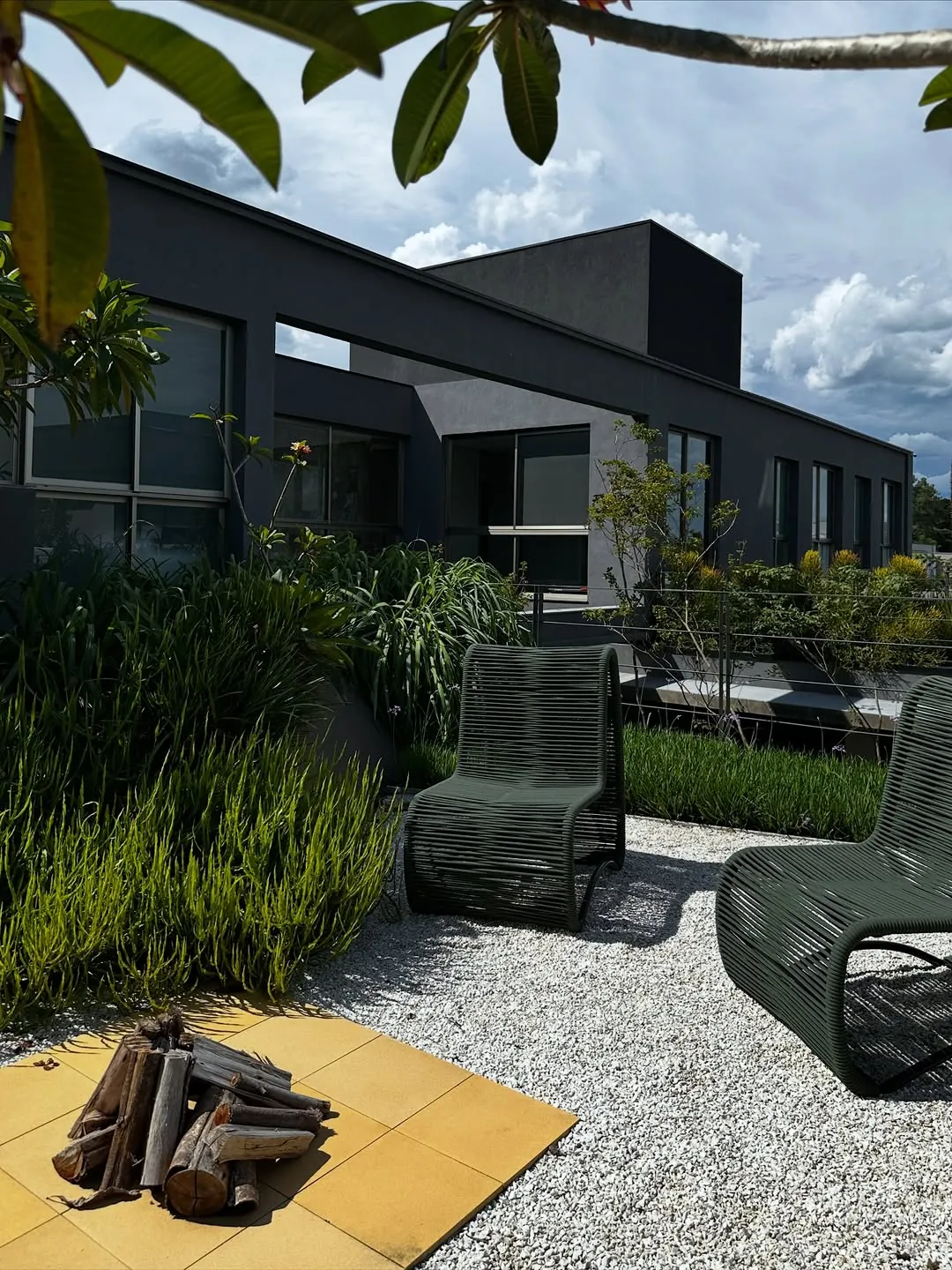 Terraço com firepit, deck e jardim sobre laje ao anoitecer